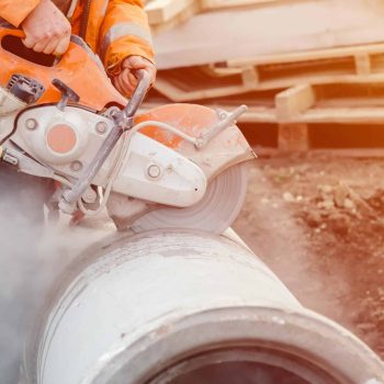 worker-construction-site-cutting-concrete-drainage-pipe-with-petrol-concrete-saw.jpg