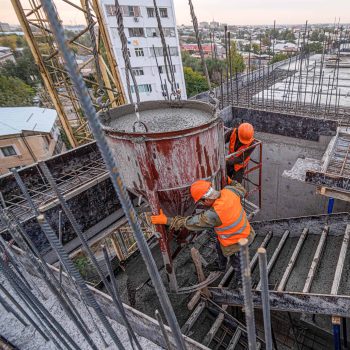 workers-building-infrastructure-roof-with-machinery-tools-pouring-concrete-into-mold.jpg